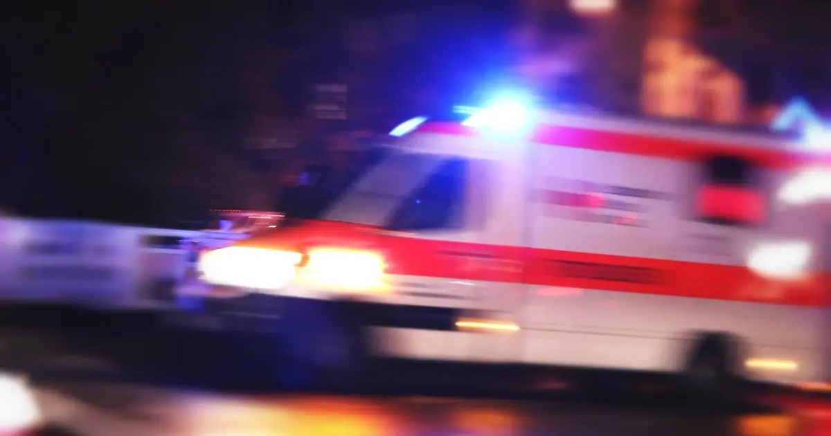 Ambulance with flashing lights responding to accident at night
