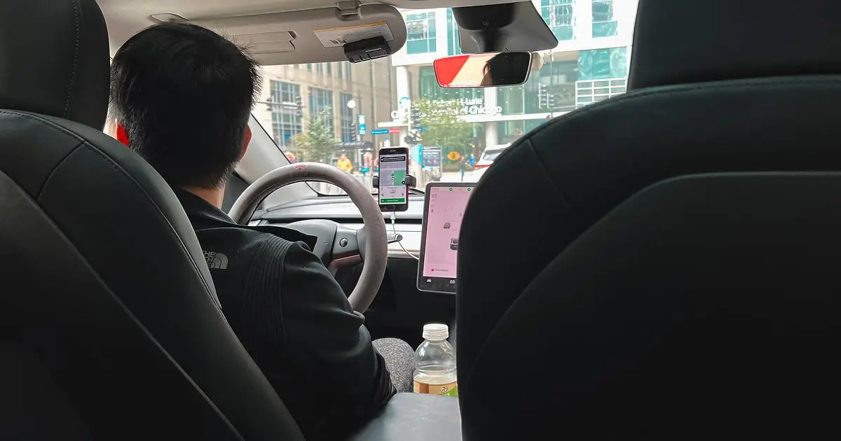 Passenger sitting in Uber rideshare with driver and navigation apps visible
