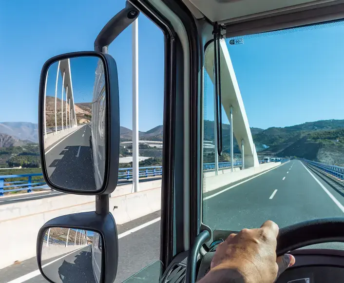 Truck driver’s view from inside the cab while driving across a bridge, representing trucking accidents and legal recovery support.