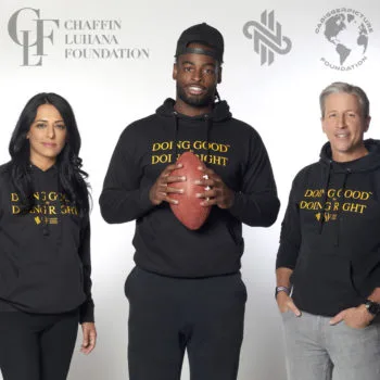 NFL running back Najee Harris partners with Chaffin Luhana Foundation to support community initiatives, holding a football alongside Roopal Luhana and Eric Chaffin.