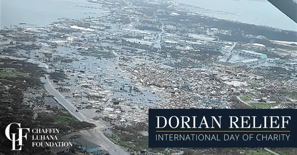 Aerial view of devastation in the Bahamas after Hurricane Dorian, with text noting Chaffin Luhana Foundation Dorian Relief for International Day of Charity.