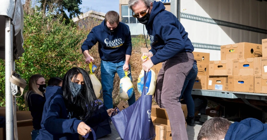 Chaffin Luhana team members distribute turkeys and food boxes during a community Thanksgiving giveaway event.